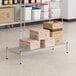 A Regency stainless steel wire dunnage rack shelf with boxes on it.