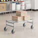 A Regency stainless steel wire dunnage rack with boxes stacked on it.