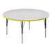 A white round table with a yellow trim and black metal base.