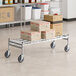 A Regency stainless steel wire rack cart with boxes on it.