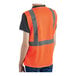 A person wearing a Lavex orange high visibility safety vest with reflective stripes.
