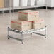 A stack of boxes on a Regency stainless steel wire dunnage rack.