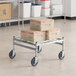 A Regency stainless steel wire cart with boxes on it.
