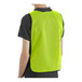 A man wearing a lime high visibility safety vest with a back view.