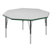 A white hexagon Correll activity table with black legs and green T-mold.