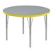 A close-up of a round Correll activity table with a gray and yellow top.