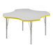 A white Correll activity table with a yellow clover shape in the middle.