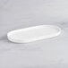 An Acopa Lore bright white rectangular porcelain platter with raised rims.