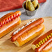 Tofurky vegan hot dogs with mustard and ketchup on a wooden board.