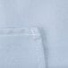 A close up of a light blue rectangular fabric with white stitching.