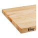 A wooden Choice cutting board with squared edges on a table.