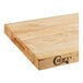 A Choice wood cutting board with squared edges on a table in a professional kitchen.