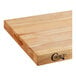 A close up of a Choice wood cutting board with squared edges on a table in a home kitchen.