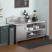 A Regency stainless steel beverage table with a sink on a counter.