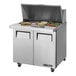 A True refrigerated sandwich prep table with food trays on the counter.