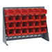 A Quantum steel bench rack with red bins on a metal stand.