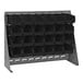 A gray steel bench rack with black bins on it.