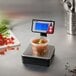 A Taylor digital portion scale with soup in a container on a counter.
