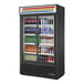 A black True refrigerated glass door merchandiser full of drinks.