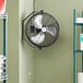 A Boltic wall-mounted fan hanging on a wall.