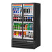 A True black narrow refrigerated glass door merchandiser full of drinks.