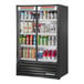 A True black refrigerated glass door merchandiser full of drinks.