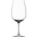 A close-up of a clear Stolzle Bordeaux wine glass with a stem.