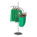 A spiral clothing rack with green shirts hanging on it.