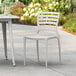 A white plastic chair and table on an outdoor patio.