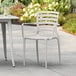 A white resin arm chair and table on a patio.