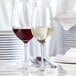 A couple of Stolzle chardonnay wine glasses on a table.