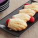 A plate of White Toque Madeleines with powdered sugar on top.