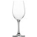 A close-up of a clear Stolzle Chardonnay wine glass with a stem.