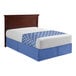 A bed with a blue and white bed sheet on it.