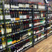 A shelf of wine bottles in a beer cave cooler.