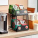 A Keurig coffee machine and K-Cups on a counter with a Keurig K-Cup storage rack.