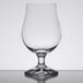 A Stolzle tulip beer glass with a clear stem on a table.
