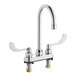 A silver American Standard deck-mount faucet with two wrist blade handles.