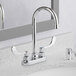 A white bathroom counter with an American Standard deck-mount faucet with wrist blade handles.