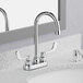 An American Standard deck-mount lavatory faucet with wrist blade handles on a countertop.