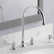 An American Standard deck-mount faucet with wrist blade handles above a sink.
