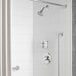 A bathroom with a white shower featuring an American Standard Colony Pro valve and shower trim kit with both a shower head and hand held shower head.