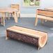 A Whitney Brothers large live edge wood log bench with a table in a classroom.