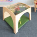 A Whitney Brothers wooden toddler reading retreat with a green floor mat on top of a table with a tree design.