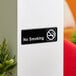 A black and white Lavex No Smoking sign on a white wall.