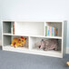 A Whitney Brothers green and white toddler shelf holding stuffed animals.