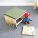 A teddy bear sits on a Whitney Brothers wood cushioned pod rocker next to a book.