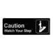 A black and white rectangular sign that says "Caution Watch Your Step" in white text.