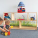 A boy and girl playing with toys on a Whitney Brothers wood cabinet.