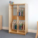 A Whitney Brothers wood hanging bag storage cabinet with books in plastic bags on the shelves.